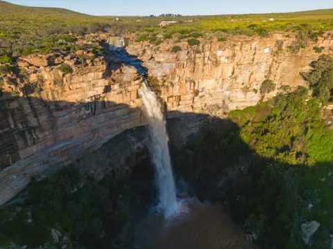 The waterfall and the sandstone gorge it has cut, with the plain beyond